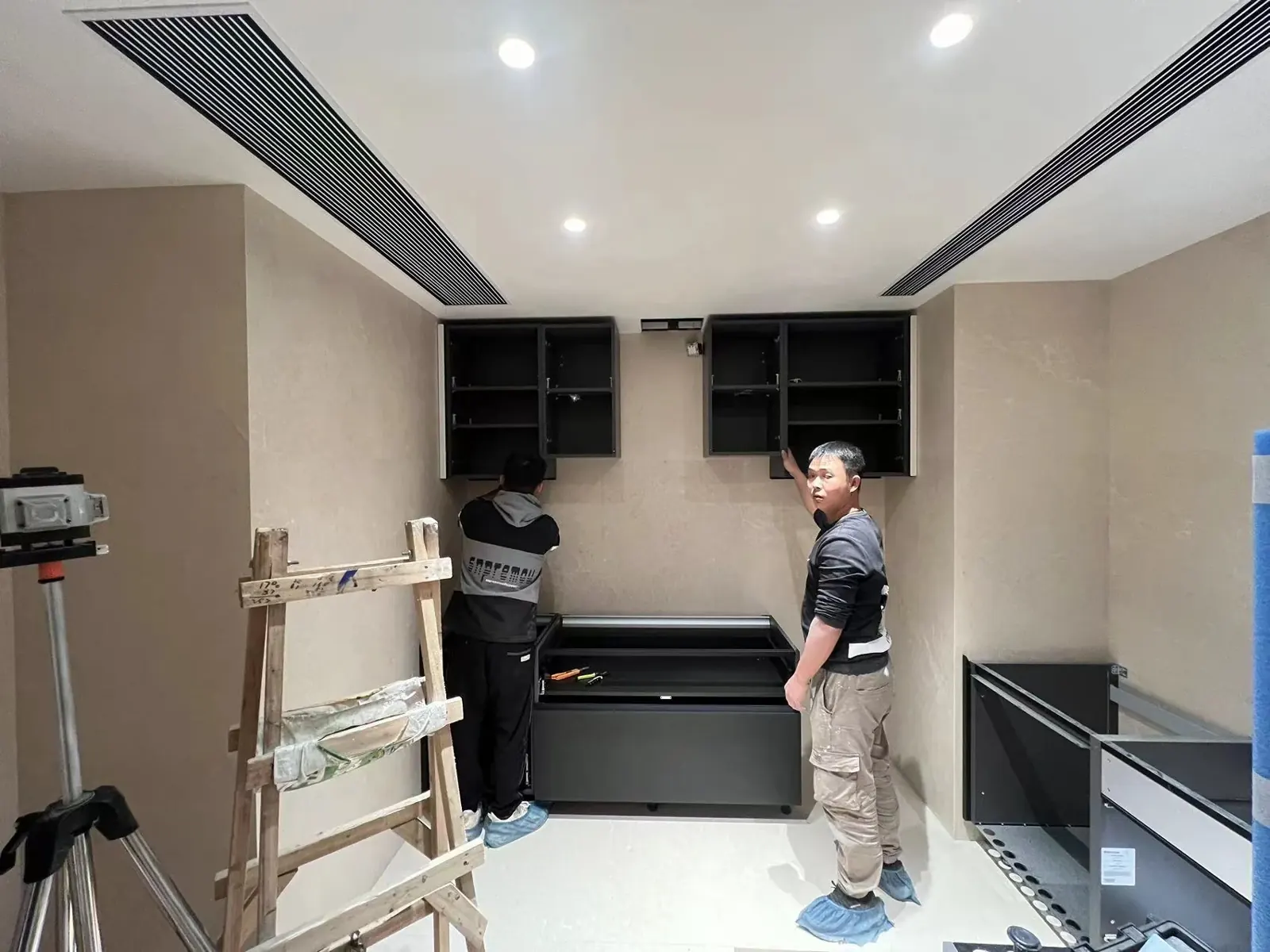 Installation team assembling cabinetry inside a customer interior